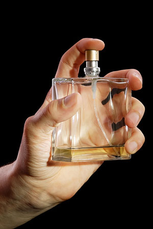 man holding a cologne bottle